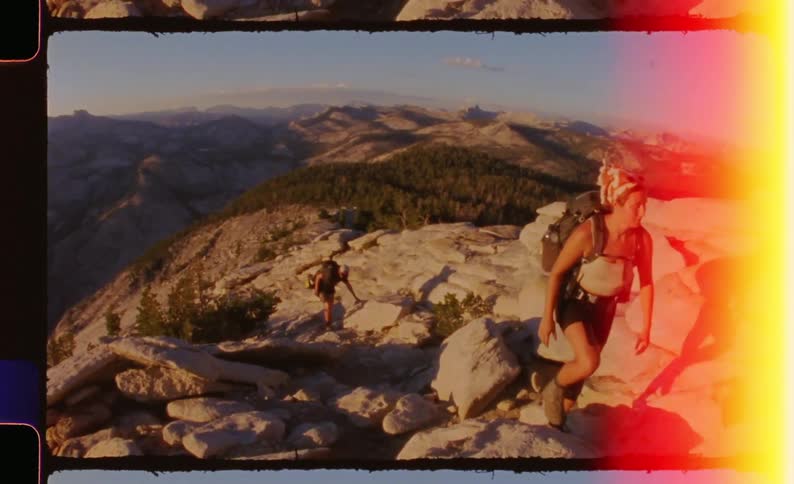 Two people climbing a rocky mountain