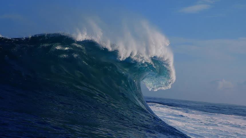 Huge wave splashes and stretches as it rolls in to shore