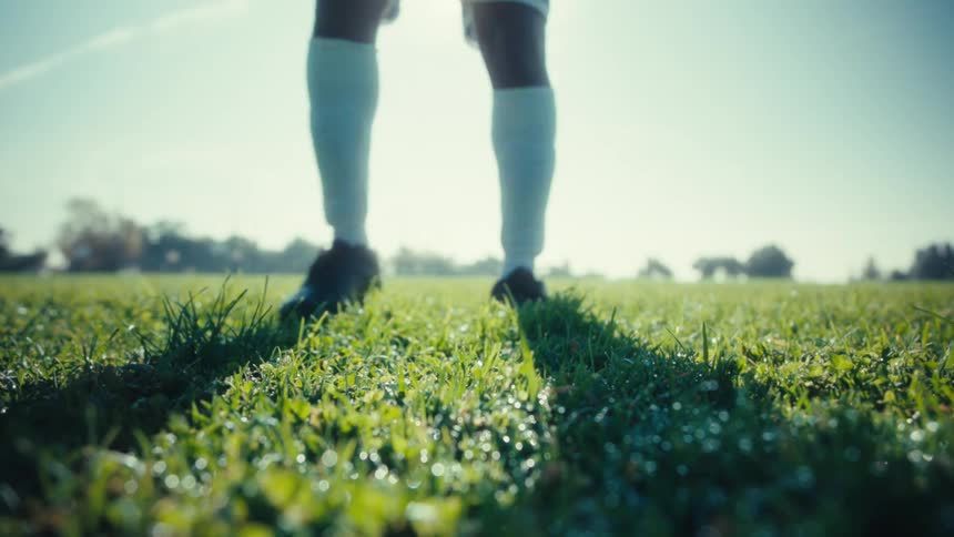 Man positioning a soccer ball on the grass