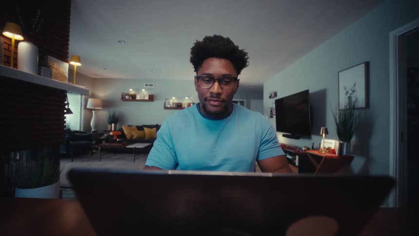 A man sitting down and using a laptop
