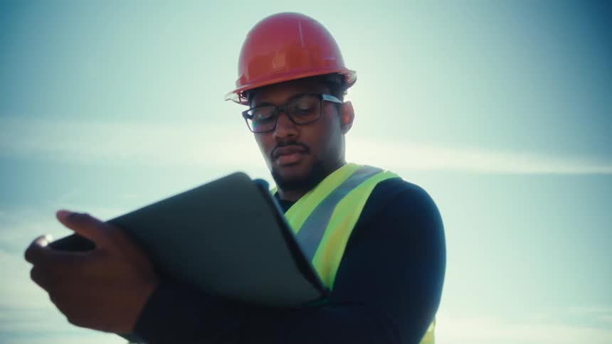 Utility worker standing outside holding a tablet computer