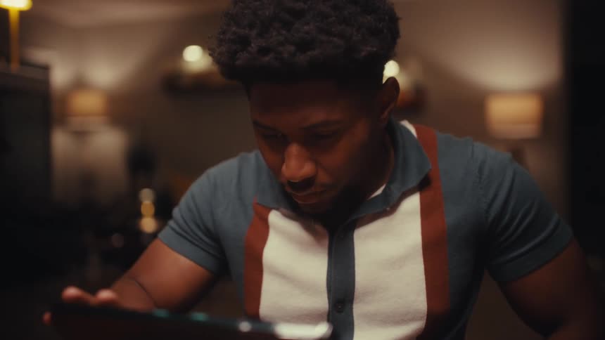 Young man sitting at a table working on a laptop computer