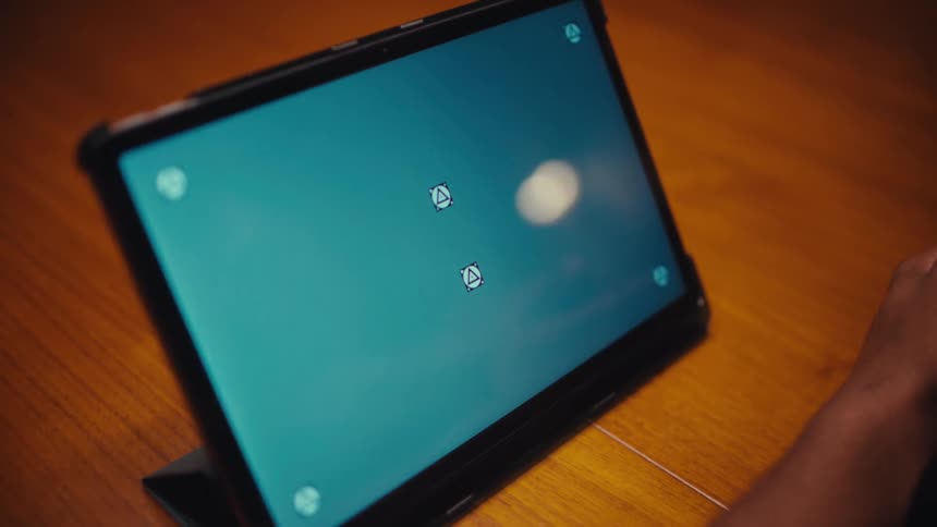 Man sitting at a table looking at a tablet computer with a replacement screen