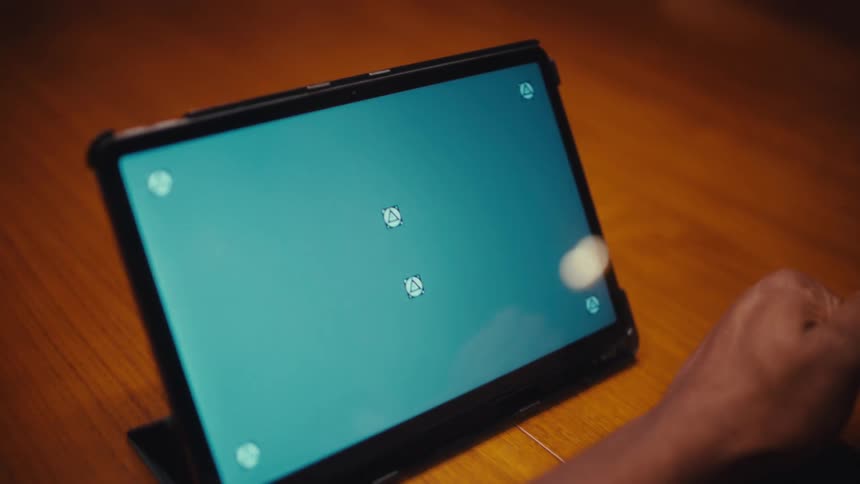 Man sitting at table with a tablet computer with a replacement screen