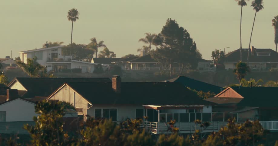 Light fog covers a residential neighborhood of large houses on a summer day