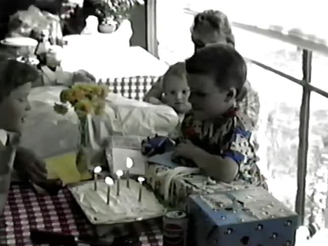 A kid blwoing out candles on a cake