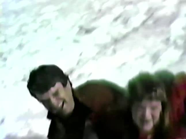 A family playing on a sled