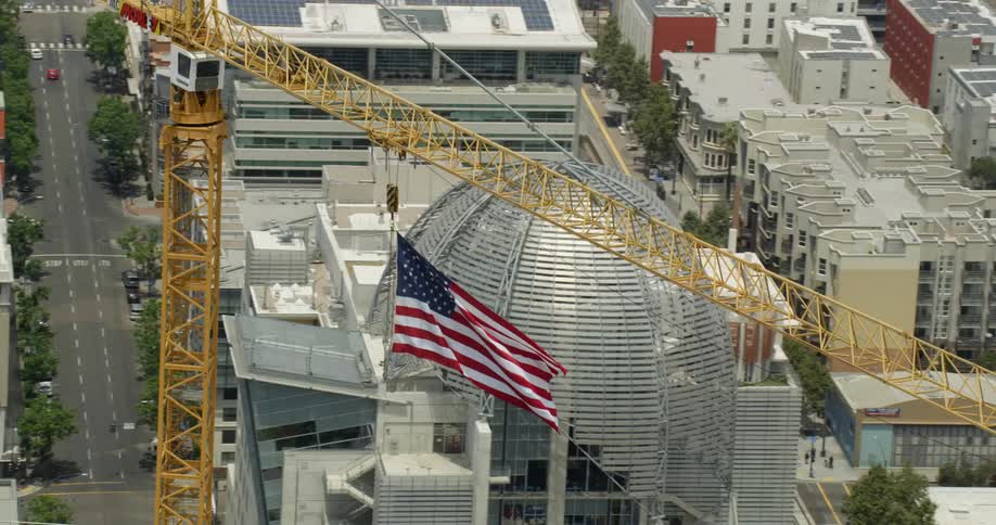 An american flag flies from a crane in San Diego, California