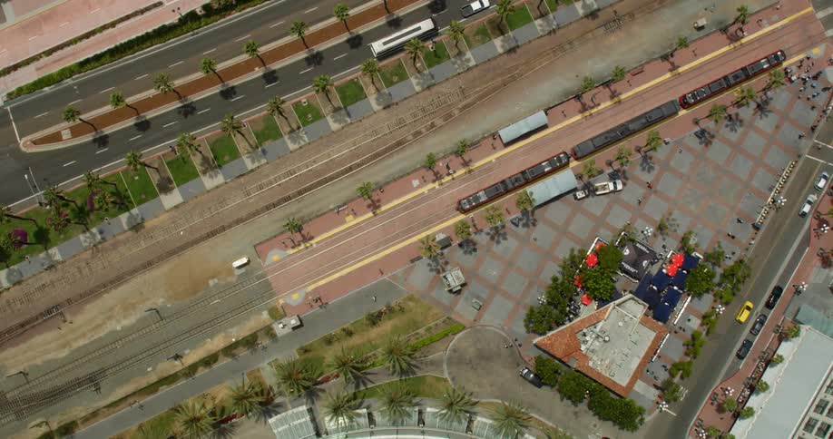 Aerial view  of a train moving on its tracks next to a skyscraper in Downtown San Diego, California
