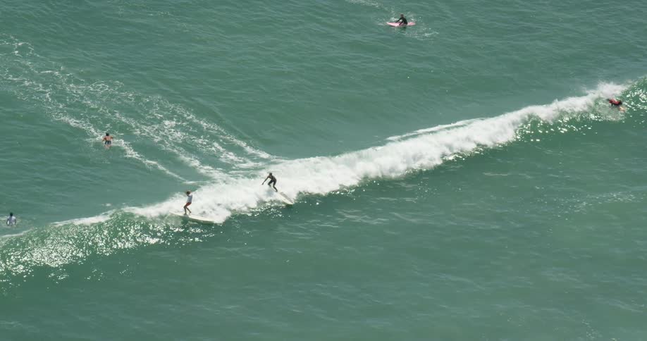 Many people surfing in calm ocean water in San Diego, California