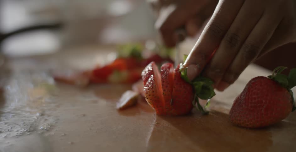 A person slicing strawberries