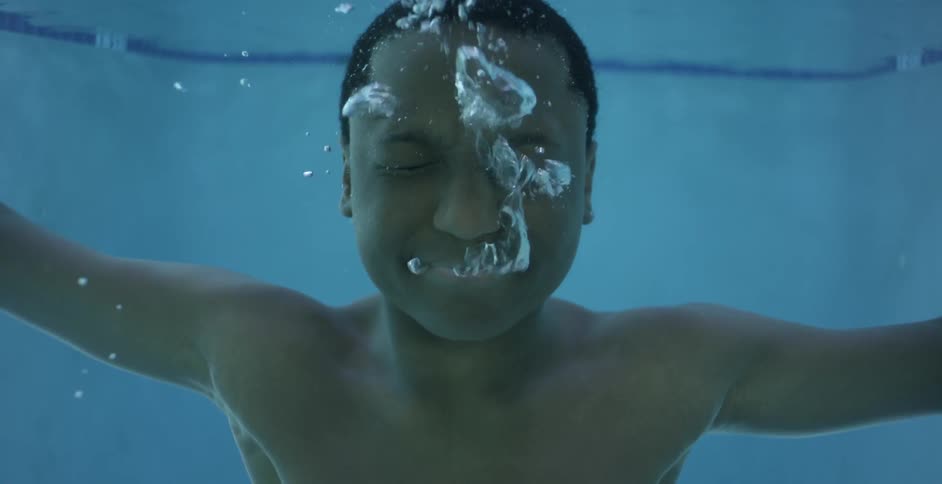 A man blows out his nose underwater
