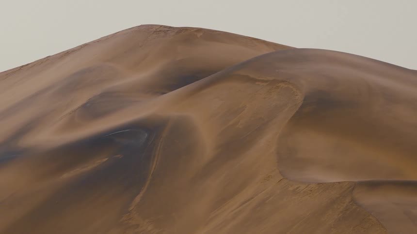 Sunlight shines on desert mountain dunes