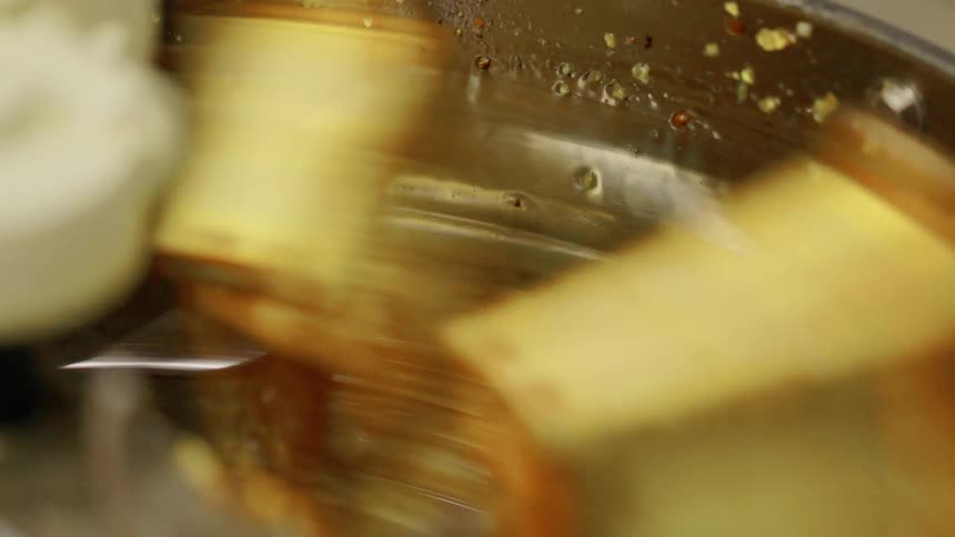 A close view inside a metal machine shows multiple rectangular objects spinning rapidly in a circular motion within a container