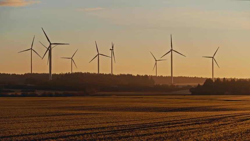 Turbines spinning on a wind farm overlooking rural farmland
