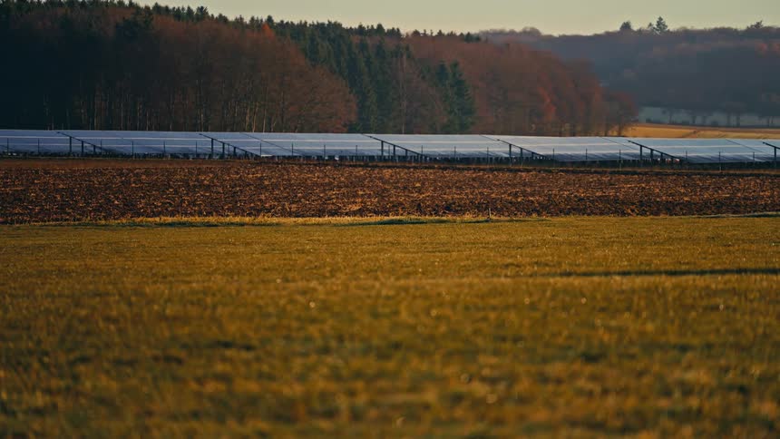 A solar field containing multiple solar panels during daytime