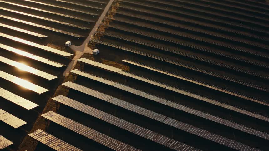 Sunlight shines on solar panels on a solar farm