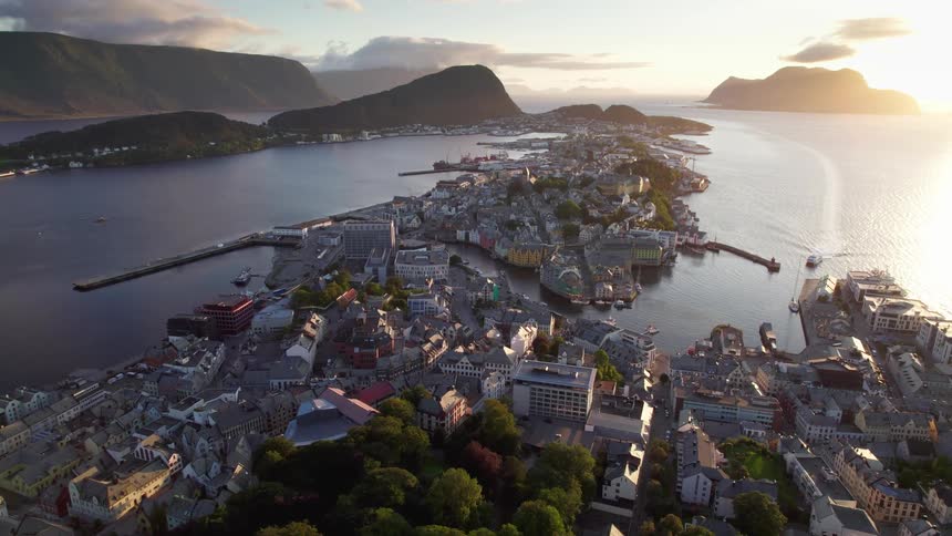 Narrow peninsula that extends from the foreground toward the horizon densely packed with buildings and infrastructure the natural coastline of the surrounding mountainous islands which runs parallel to the peninsula and frames the body of water on the