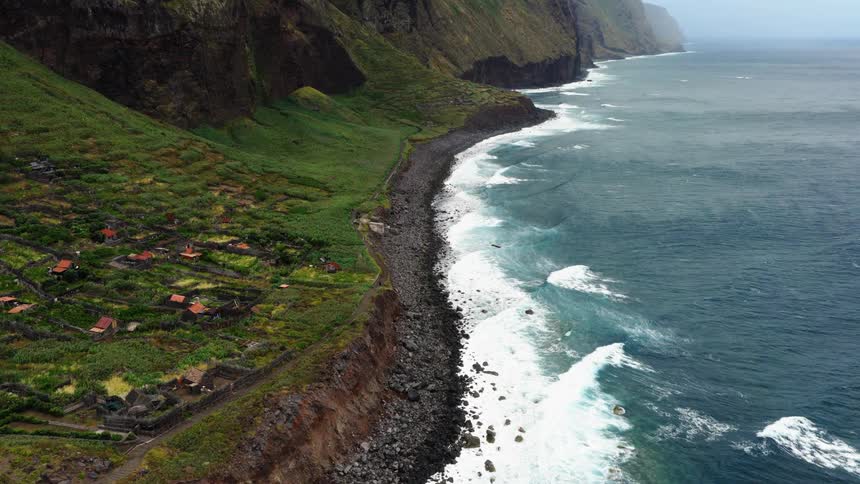 The waves crash against the small town on the shore