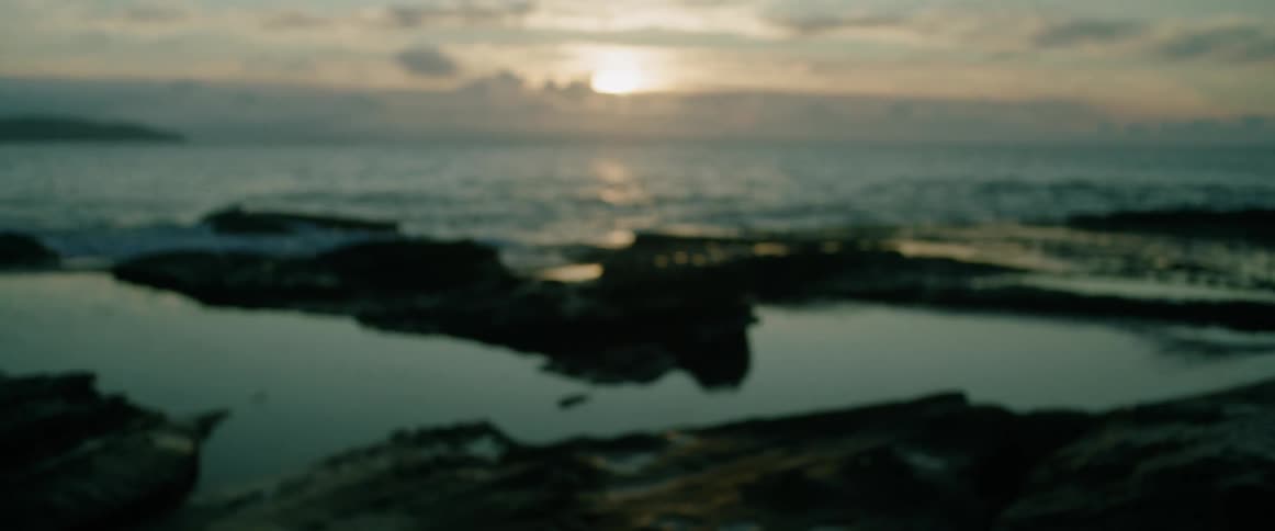 Rocky seaside landscape with the sunrise on the horizon