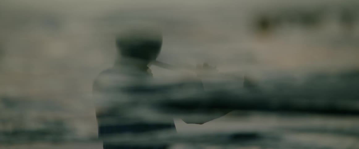 Blurred silhouette of a person extends an arm in front of a watery setting