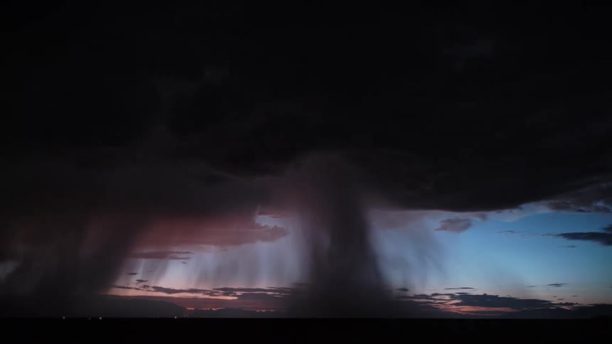 Thunder and lightning on a storm with tornadoes over a field outdoors during dusk or dawn