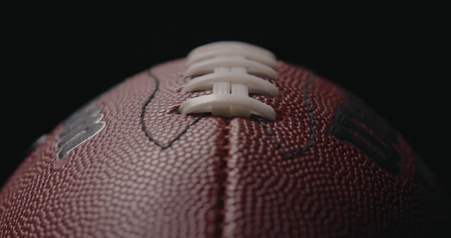 Lights brighten to illuminate a football