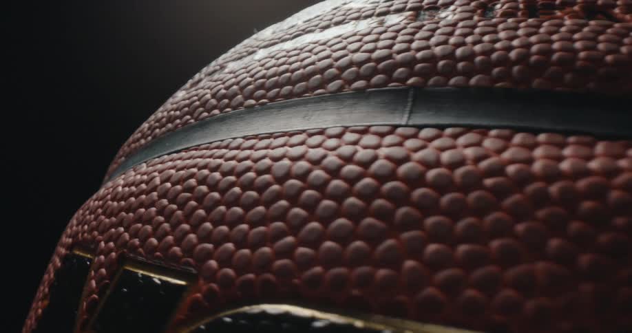 Close up of a rotating basketball in a dark photo studio