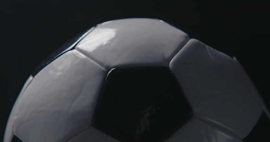 Black and white soccer ball lit from the side