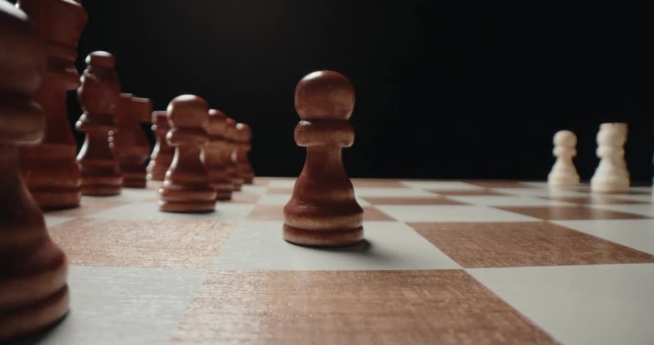 A person playing chess as he moves a piece forward