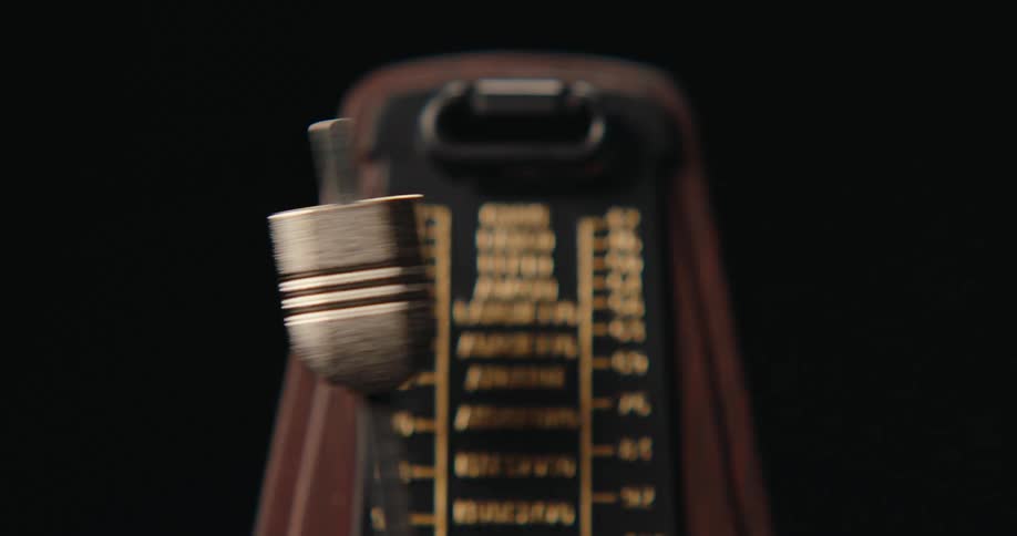 Vintage metronome with swinging metal pendulum and tempo markings from largo to presto
