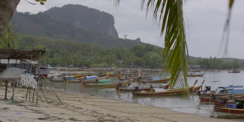Many small boats docked on an island beach