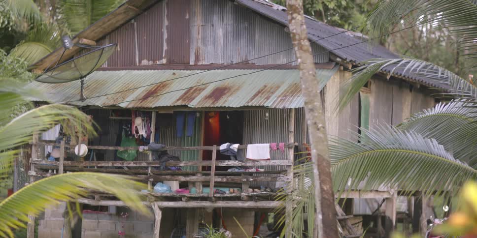 Clothes hang on the porch of a tattered building