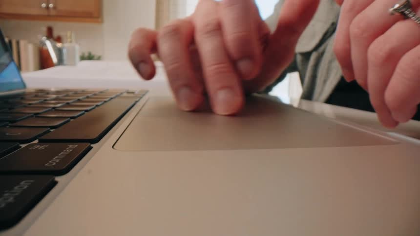 Person types on modern laptop in welllit home setting