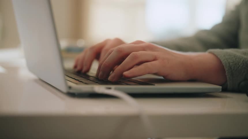 A person typing on a laptop computer
