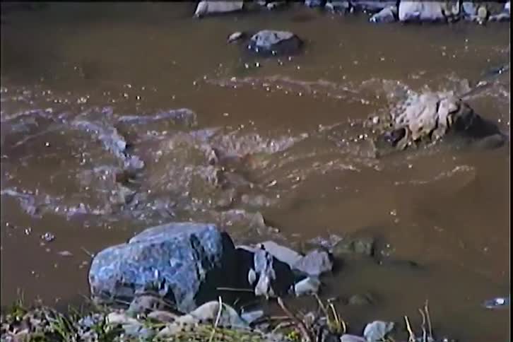 Flowing water in a small river with small rocks at daytime