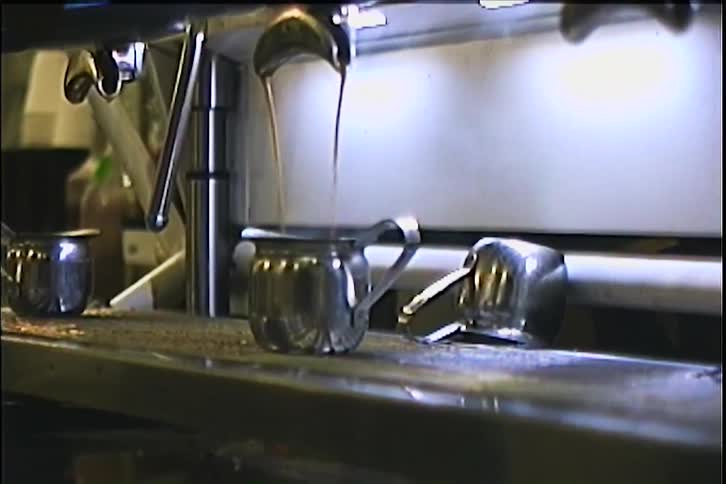 A coffee maker sits on a counter in a restaurant with a glass jug positioned underneath steadily collecting freshly brewed coffee as it pours