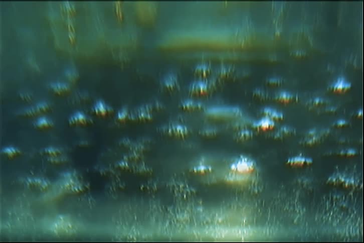 Bubbles rise in blue liquid with reflections