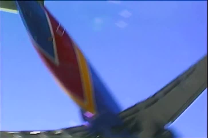 Commercial airplane seen from below during landing approach under a blue sky