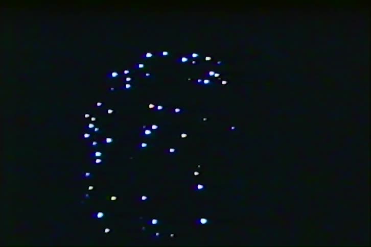 Suspended lights form bright pattern against dark background