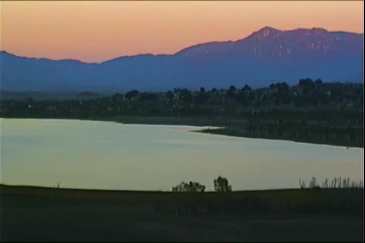 Landscape of a lake surrounded by mountains at dawn