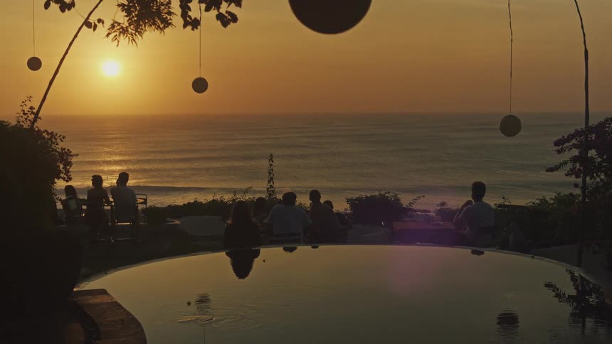 A clear horizontal boundary where the orange sky meets the dark ocean bisecting the frame