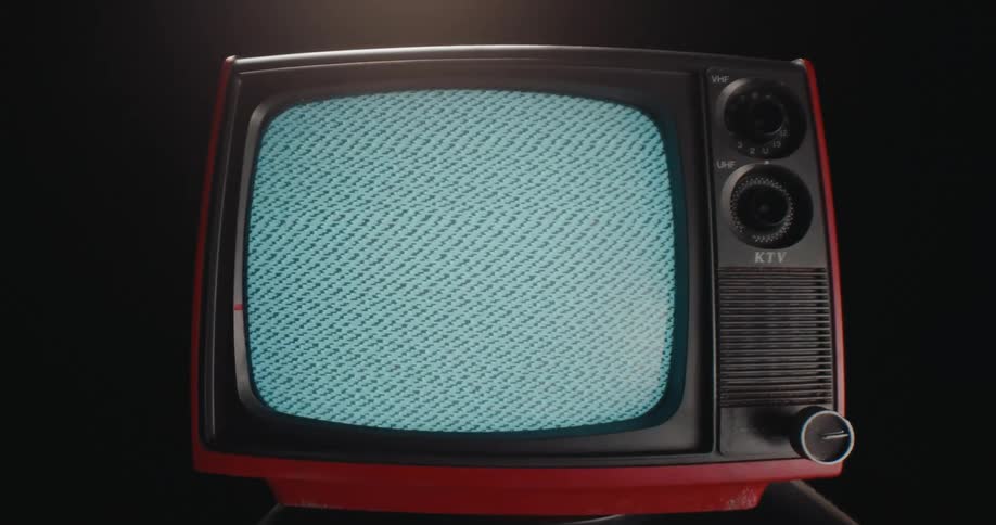 A vintage 13inch ktv television with black and red borders displays a grainy image on its screen