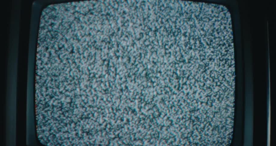 Static on the screen of an old television in a dark room