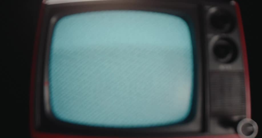 Vintage red television with blue screen displaying white text in dark setting