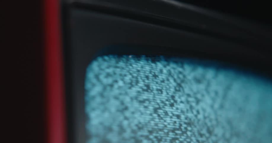 A closeup angled shot shows the flickering grey and white static on an old television screen
