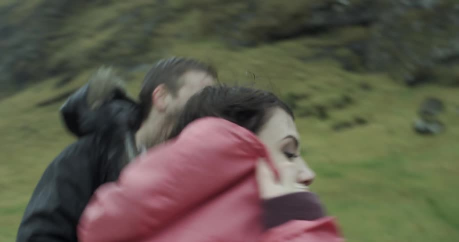 A couple run in the rain together