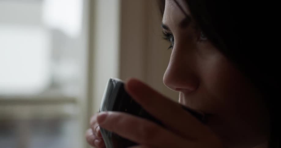 A woman drinks from her mug