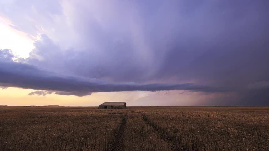 Lightning flashes as storm clouds move over a barn on rural farmland