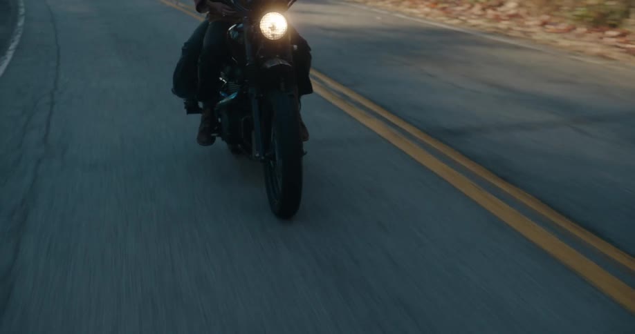 Person riding a motorcycle on a paved road
